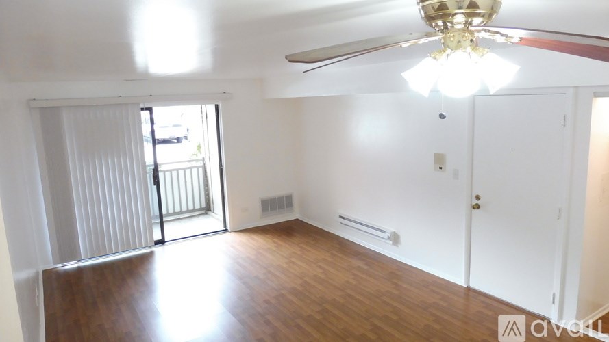 A room with a ceiling fan and a sliding glass door.