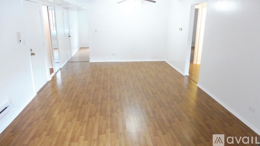 A room with wooden flooring and white walls.