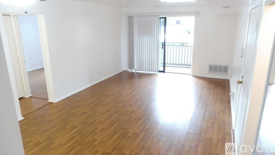 A room with wooden flooring and white walls.