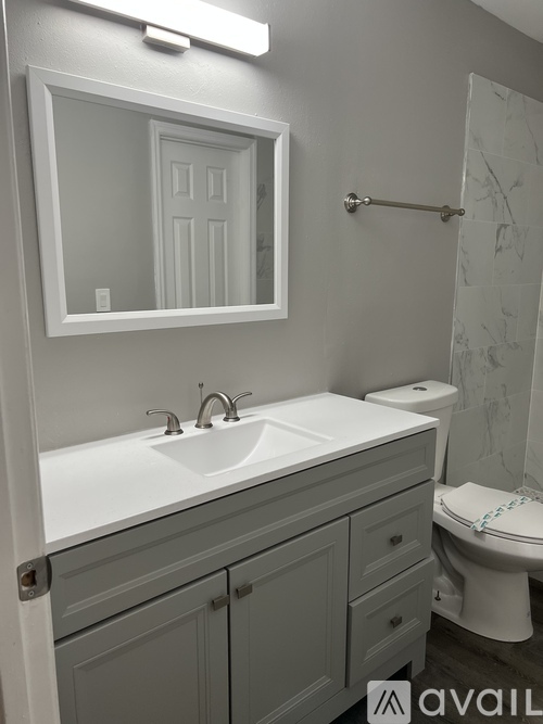 A bathroom with a white sink and a mirror above it.