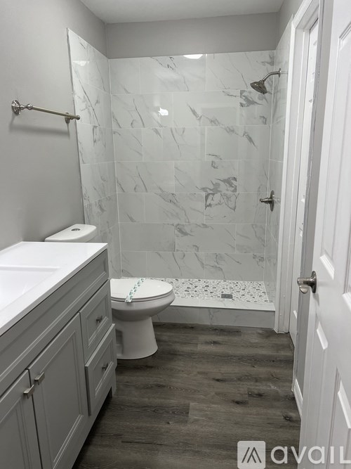 A bathroom with a toilet, sink, and walk-in shower.