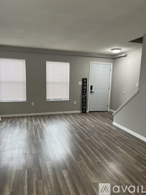 A room with wooden flooring and a white door.