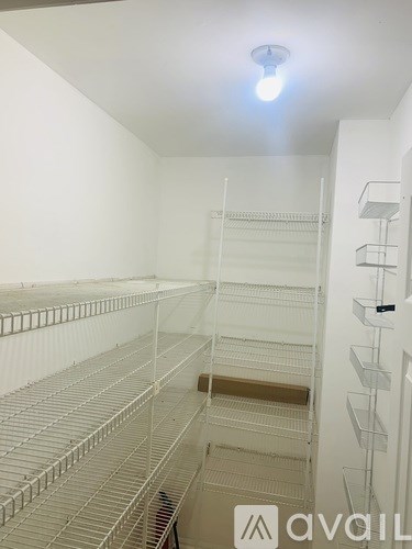 Empty white shelves in a room with a light on the ceiling.