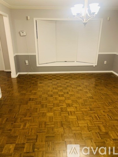 A room with a wooden floor and a chandelier.