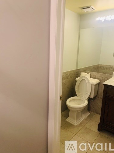 A white toilet is in a bathroom with a white door.