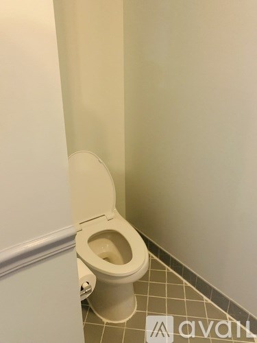 A toilet with the seat up in a bathroom.
