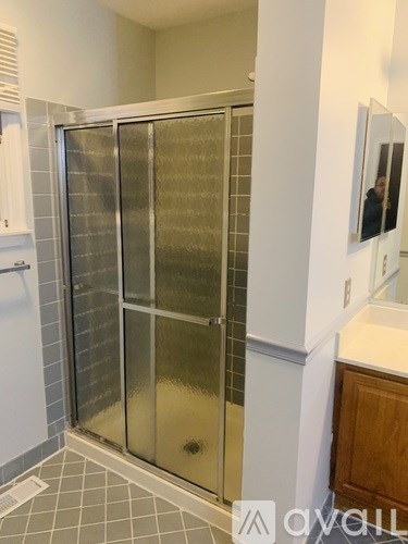 A shower with a glass door is in a bathroom.