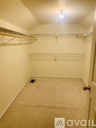 A small, empty room with a carpeted floor and a door on the right.