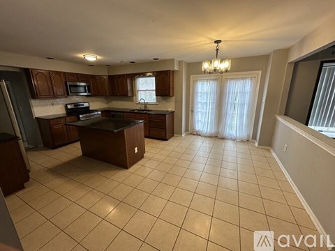 A kitchen with a black stove top oven and a black refrigerator.