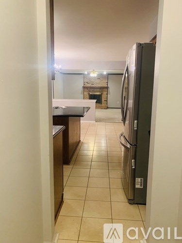 A kitchen with a refrigerator, sink, and countertop.