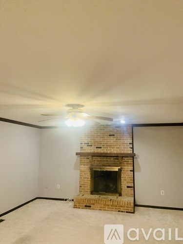 A room with a fireplace and a ceiling fan.