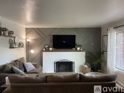 A living room with a brown couch and a fireplace.