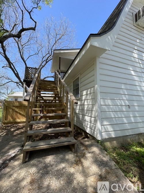 A wooden staircase outside a white house.