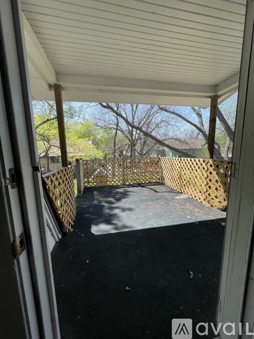 A patio with a white door and a wooden fence.