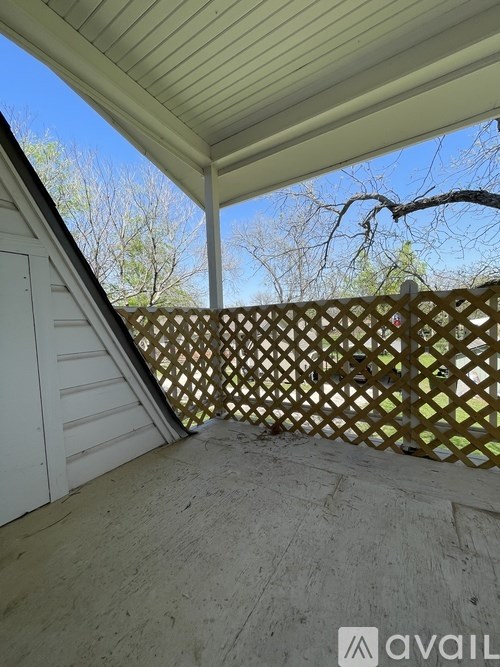 A patio with a lattice fence and a white door.