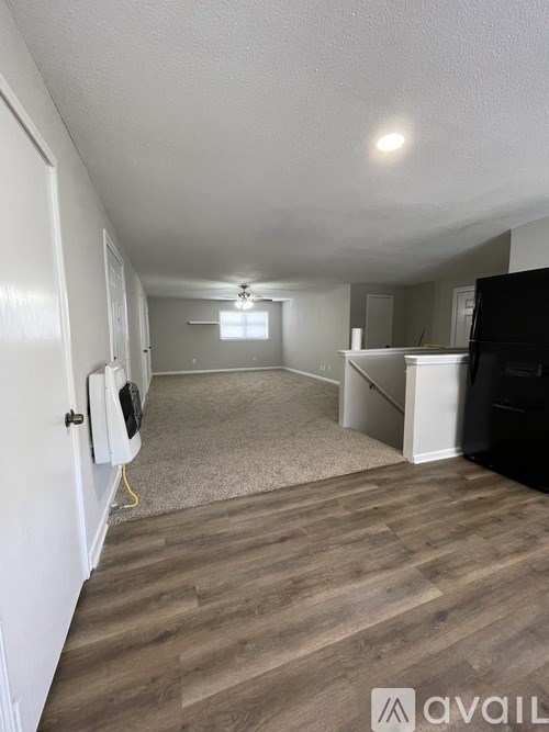 A room with a white door, a window, and a black refrigerator.
