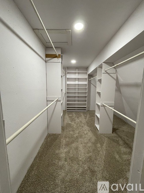 A long, narrow hallway with white walls and a carpeted floor.