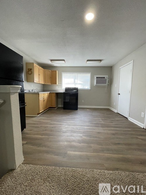 A kitchen with black appliances and wooden cabinets.