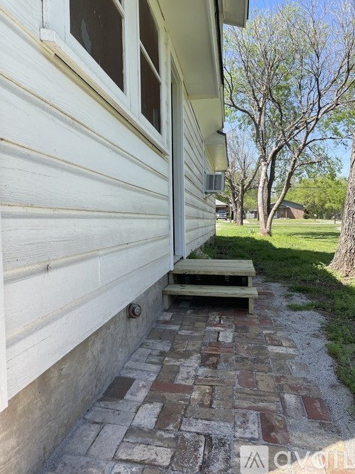 A white house with a bench in front of it.