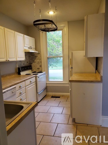 A kitchen with white cabinets and a window.