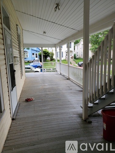 A porch with a red bucket on it.