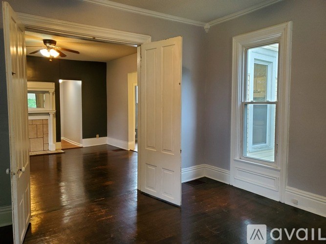 A room with a ceiling fan and a window.