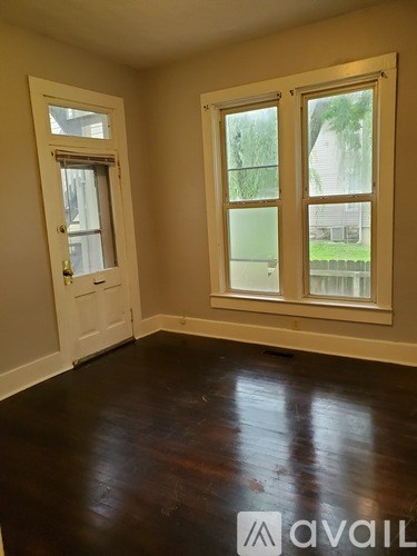 A room with a door and two windows.