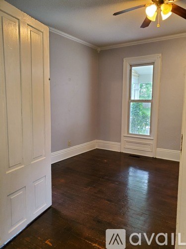 A room with a window and a fan.