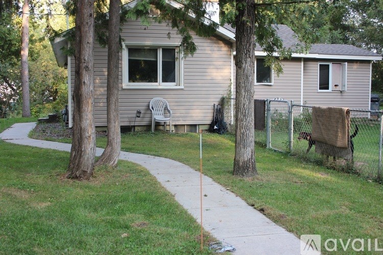 A house with a white door and a window is surrounded by a fence.