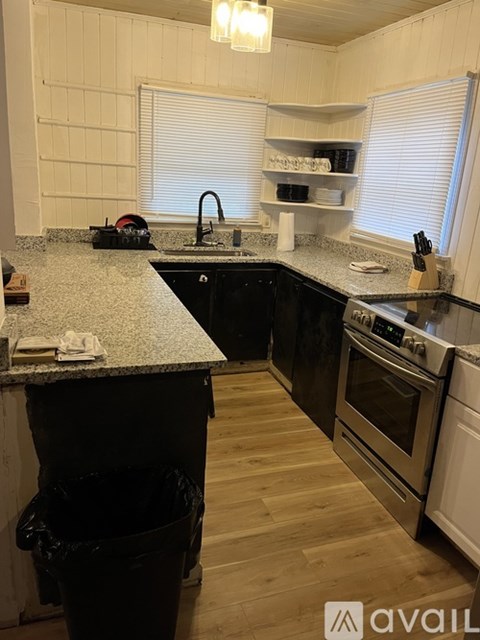 A kitchen with black cabinets and a granite countertop.