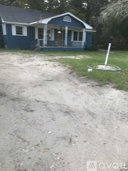 A blue house with a white door and a porch.