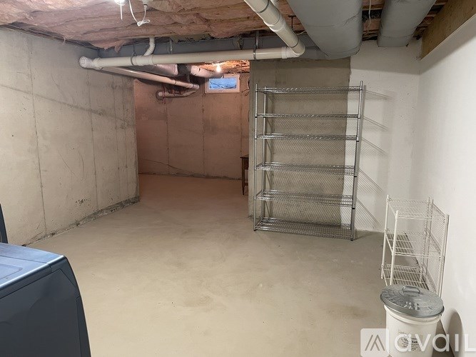 A room with a metal shelving unit and a grey table.