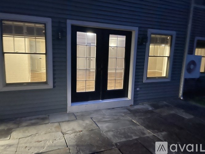 A house with a black door and windows is shown.