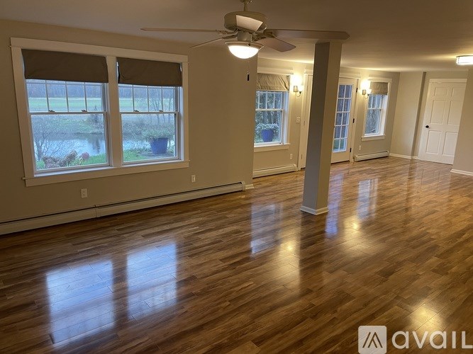 A room with wooden floors and a ceiling fan.