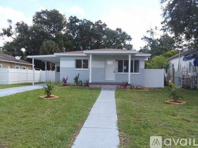 A house with a white fence and a small garden in front.