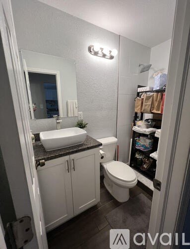 A bathroom with a toilet, sink, and mirror.
