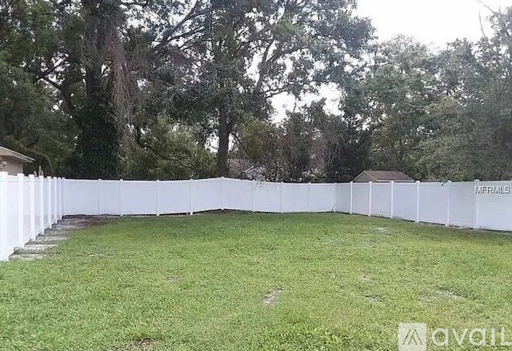 A white picket fence surrounds a grassy yard.
