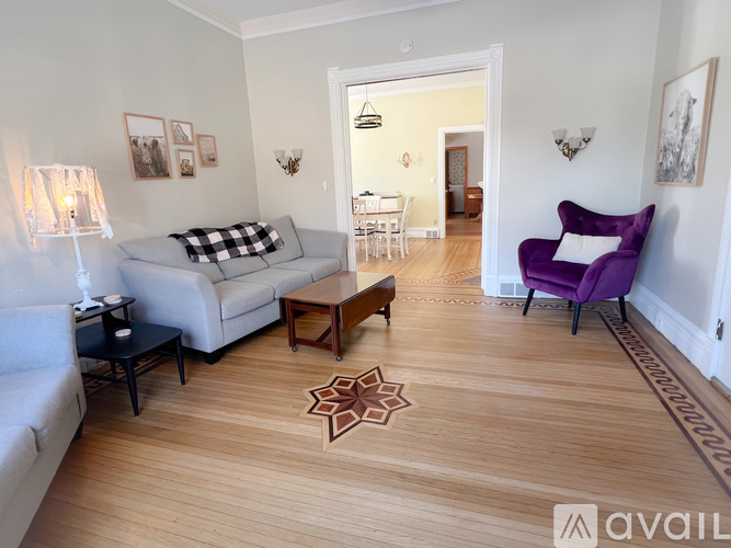 A living room with a purple chair and a television.