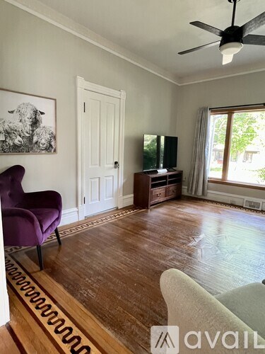 A living room with a purple chair and a television.