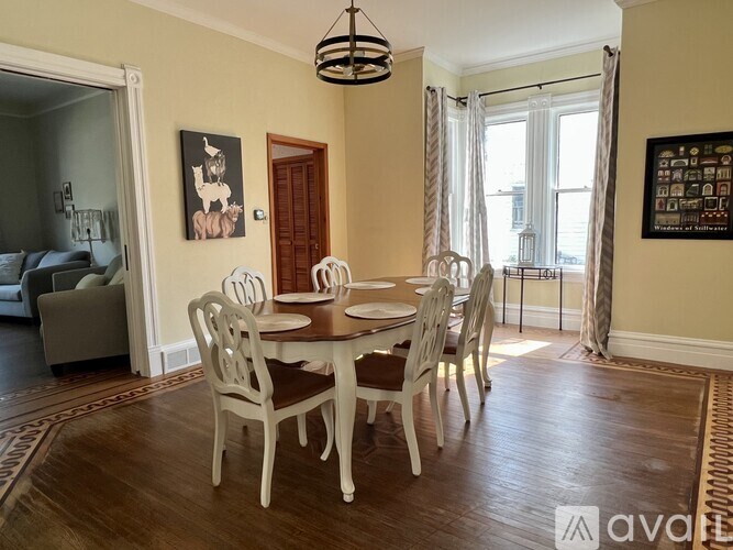 A dining room with a round table and chairs.