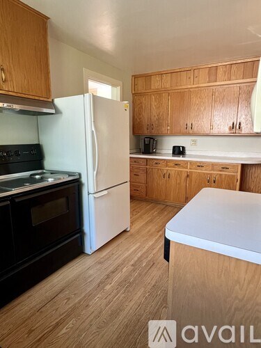 A kitchen with wooden cabinets and a white fridge.