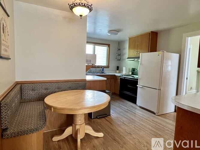 A kitchen with a white refrigerator and wooden floors.