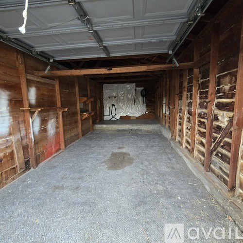 A large, empty room with wooden walls and a concrete floor.