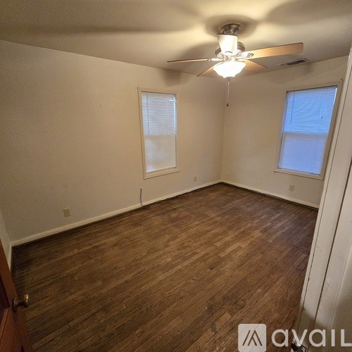 A room with wooden flooring and a ceiling fan.