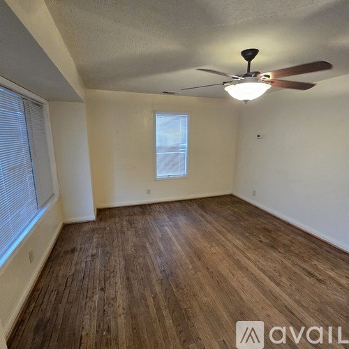 A room with wooden flooring and a ceiling fan.