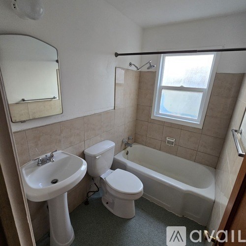 A bathroom with a white toilet, sink, and bathtub.