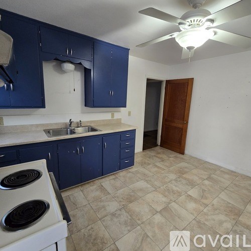 A kitchen with blue cabinets and a white stove.