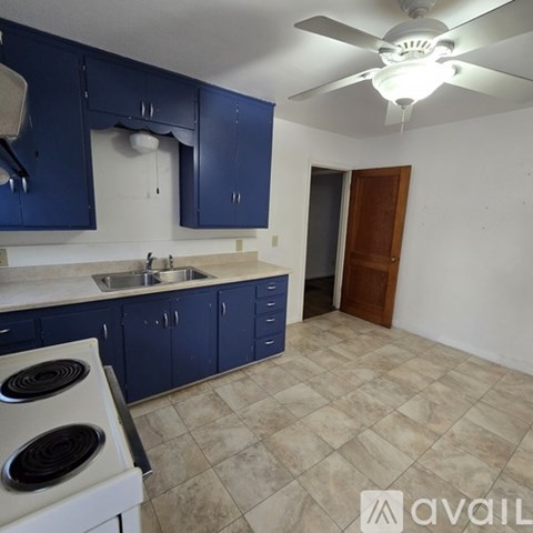 A kitchen with blue cabinets and a white stove.