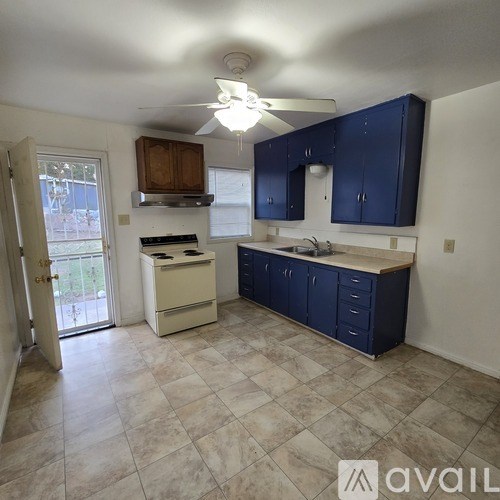 A kitchen with blue cabinets and a white stove top oven.