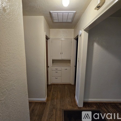 A hallway with a cabinet and drawers in the background.
